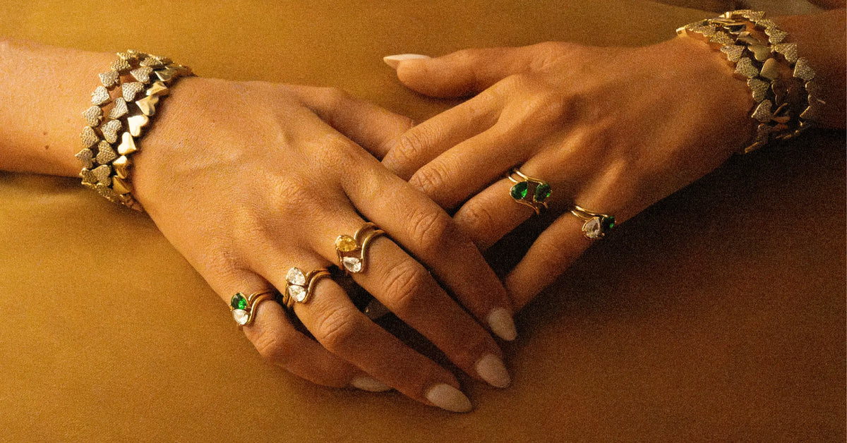 Bagues en plaqué or décorées de pierres en zirconium coupe poire et bracelets en plaqué or en forme de multiple coeur, dont certains sont pavés de zirconiums.