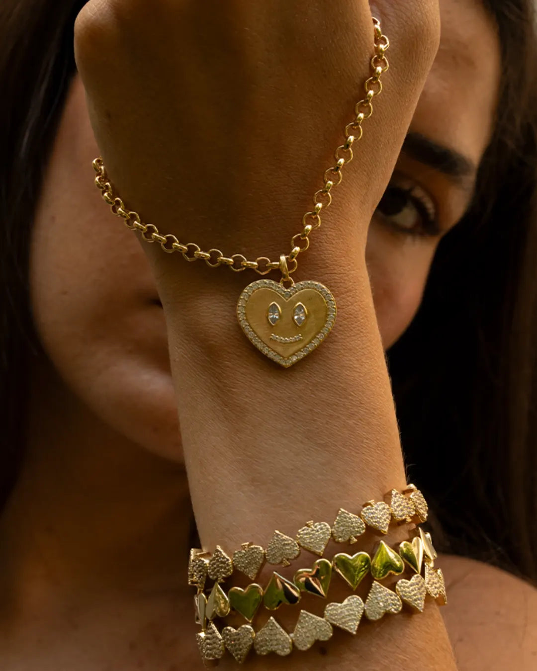 Collier en plaqué or avec une chaine et un pendentif coeur décoré de zircon. Et bracelets coeurs et piques en plaqué or. 